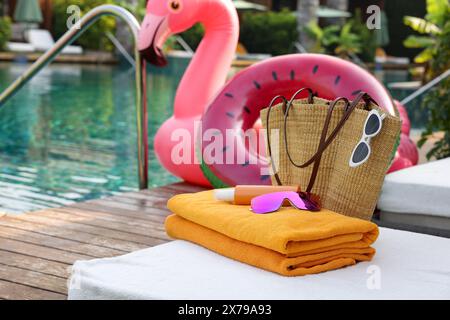 Accessori da spiaggia su lettini, anello gonfiabile e galleggiante vicino alla piscina all'aperto. Resort di lusso Foto Stock