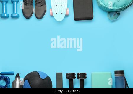 Telaio realizzato con diverse attrezzature sportive su sfondo azzurro, piatto. Spazio per il testo Foto Stock