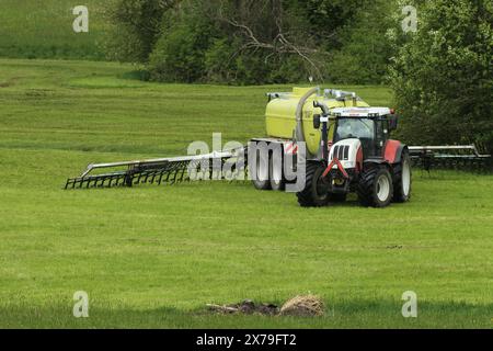 Agricoltore che spande concime liquido su prato falciato, Allgaeu, Baviera, Germania Foto Stock