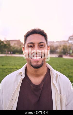 Bello uomo barbato felice. Ritratto di un giovane allegro che si trova all'aperto e sorride davanti alla macchina fotografica. Foto Stock