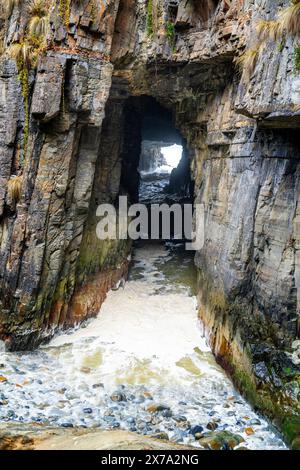 L'oceano si gonfia attraverso lo stretto abisso di Remarkable Cave, Maingon Bay, Tasmania Peninsula Foto Stock