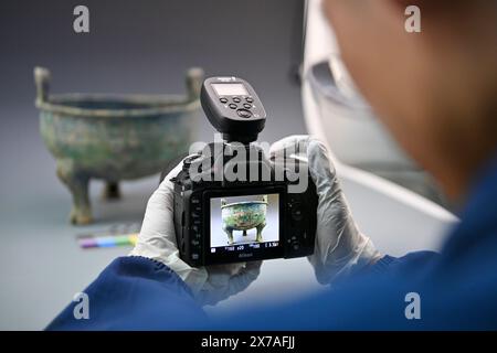 (240519) --PECHINO, 19 maggio 2024 (Xinhua) -- il restauratore di reliquie culturali Zhang Zhengmin scatta una foto di una ceramica di bronzo presso il Museo Shanxi di Taiyuan, nella provincia dello Shanxi della Cina settentrionale, 17 maggio 2024. (Xinhua/Yang Chenguang) Foto Stock