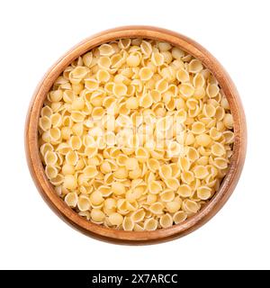 Perline o conchiglie, pastina e zuppa italiana in una ciotola di legno. Pasta minuscola, rotonda, a forma di guscio, di semola di grano duro cruda. Foto Stock