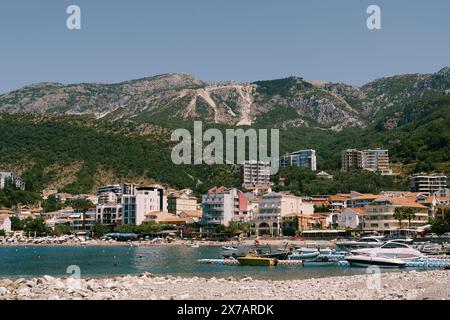 Le barche sono ormeggiate al largo della costa della località di villeggiatura sullo sfondo delle montagne Foto Stock