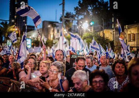 Tel Aviv, Israele. 18 maggio 2024. Durante la dimostrazione, i manifestanti generano bandiere d'onda. Il ministro israeliano Benny Gantz ha minacciato di dimettersi a meno che il primo ministro Benjamin Netanyahu non stabilisca un piano post-bellico per la Striscia di Gaza. Gantz ha fissato un termine dell'8 giugno per un piano volto a conseguire sei "obiettivi strategici”, tra cui la fine del dominio di Hamas a Gaza e l'istituzione di un'amministrazione civile multinazionale per il territorio. Credito: SOPA Images Limited/Alamy Live News Foto Stock