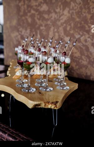 buffet alla reception. Assortimento di tartine su tavola di legno. Servizio banchetti. catering, spuntini con formaggio Foto Stock