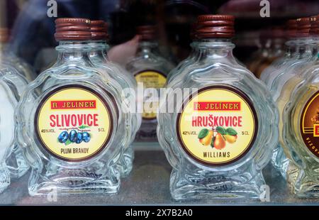Praga, Repubblica Ceca - 10 maggio 2024: Diverse bottiglie di brandy alla frutta sono esposte su uno scaffale di un mercato locale, mostrando sapori come prugna e pe Foto Stock