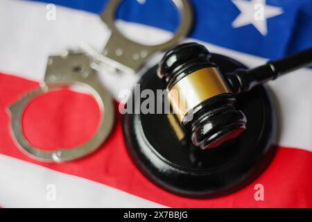 Martelletto e manette sopra la bandiera americana. Concetto di criminale e punizione. Foto Stock