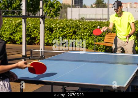 Famiglia giocando a ping-pong al di fuori casa Foto Stock