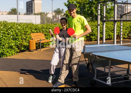 Felice uomo con sua figlia che gioca a ping pong nel parco Foto Stock