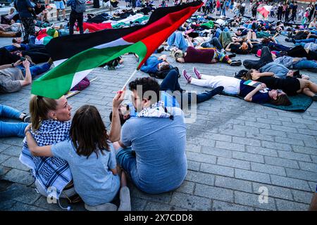 18 maggio 2024, Varsavia, Mazovia, Polonia: Una famiglia sventura una bandiera palestinese mentre i manifestanti prendono parte a una manifestazione di morte sul terreno della Piazza del Castello di Varsavia. I manifestanti pro-palestinesi tengono una dimostrazione di morte in Piazza del Castello di Varsavia. In commemorazione della Nakba a partire dal 1948, i manifestanti sono rimasti immobile sul terreno. In seguito un certo numero di palestinesi e polacchi-palestinesi raccontarono le loro storie al pubblico riunito. (Credit Image: © Neil Milton/SOPA Images via ZUMA Press Wire) SOLO PER USO EDITORIALE! Non per USO commerciale! Foto Stock