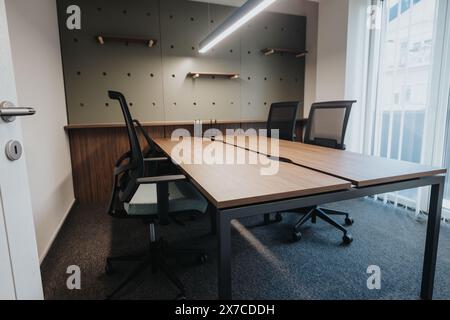 Moderna sala riunioni con tavolo in legno e sedie ergonomiche Foto Stock