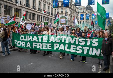 Londra, Regno Unito. 18 maggio 2024: Le attiviste climatiche marciano dietro una grande bandiera alla Nakba 76 marzo per la Palestina contro gli attacchi israeliani a Gaza nel centro Foto Stock