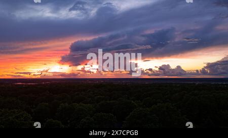 Cielo spettacolare dopo una tempesta con il sole che tramonta all'orizzonte con pioggia che scende in lontananza in alcune zone e macchie di nebbia sopra Foto Stock