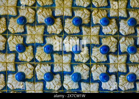 Piastrelle geometriche a motivi moreschi note come Azulejos, decorano la facciata all'interno dell'arco di Tritone che conduce al cortile degli archi del Palazzo pena o al castello storico di Palácio da pena a Sintra, Portogallo. Il castello da favola è considerato uno dei più bei esempi di architettura romanticistica portoghese del XIX secolo al mondo. Foto Stock