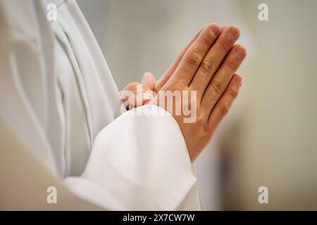 Le mani di un sacerdote consacrano un'ostia come corpo di Cristo per distribuirla ai comuni della chiesa Foto Stock