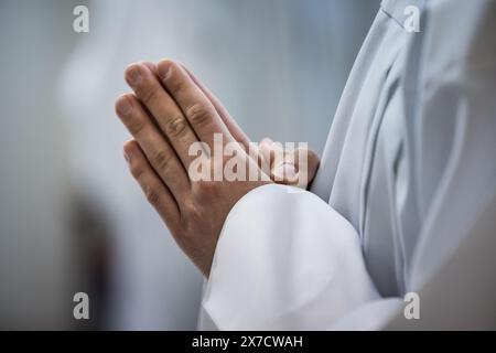 Le mani di un sacerdote consacrano un'ostia come corpo di Cristo per distribuirla ai comuni della chiesa Foto Stock