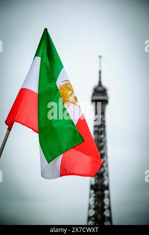 Vecchia bandiera iraniana (bandiera iraniana sotto l'ex regime Shah) e Torre Eiffel sullo sfondo. Dimostrazione a Parigi, Francia. Foto Stock