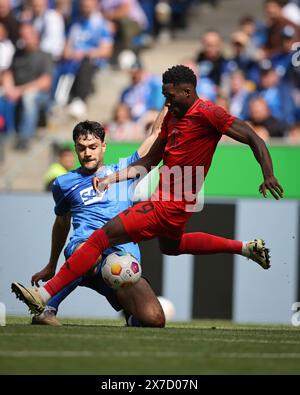 SINSHEIM, GERMANIA - 18 MAGGIO: Alphonso Davies del Bayern Muenchen si batte con Ozan Kabak del TSG Hoffenheim durante la partita di Bundesliga tra TSG Hoffenheim e FC Bayern München al PreZero-Arena il 18 maggio 2024 a Sinsheim, Germania. © diebilderwelt / Alamy Stock Foto Stock