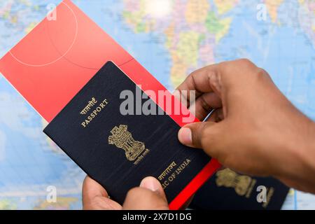 Questa immagine tratta di un primo piano di un uomo con passaporto e carta d'imbarco sul concetto di viaggio di sfondo della mappa mondiale Foto Stock