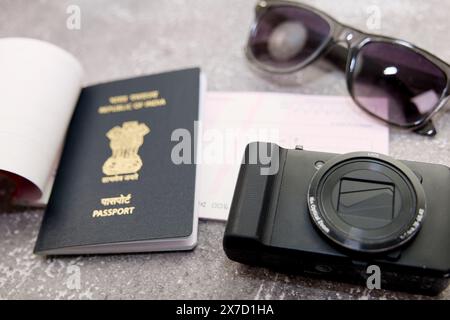 Questa immagine tratta di una macchina fotografica per passaporto indiano e occhiali da sole su sfondo grigio Foto Stock