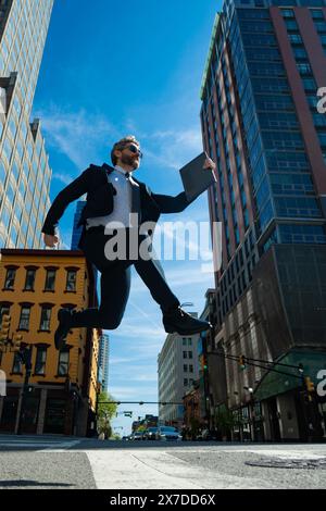 Uomo d'affari che salta per strada. Avanti salto e passi. Concetto di ambizioni aziendali. Strategia di successo aziendale. Sviluppo della crescita creativa Foto Stock