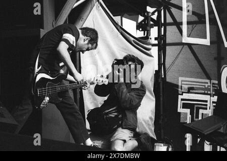 FOTOGRAFO ROCK, MATT SHARP, WEEZER, NME STAGE, GLASTONBURY 1995: Un fotografo rock fotografa il bassista originale Matt Sharp (maglia n. 7) dei Weezer suona il secondo stadio NME al Glastonbury Festival, Pilton Farm, Somerset, Inghilterra, giugno 1995. Nel 1995 il festival ha celebrato il suo 25 ° anniversario. Foto: ROB WATKINS. INFO: Weezer è un gruppo musicale statunitense formatosi nel 1992, noto per le loro melodie accattivanti e i testi eccentrici. Con successi come "Buddy Holly" e "Island in the Sun", hanno guadagnato una base di fan devoti e una significativa influenza nell'alternative rock. Foto Stock