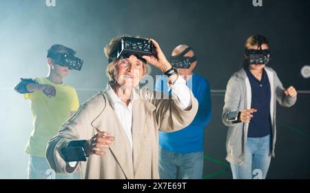 Nonna stupita in VR club con la famiglia Foto Stock
