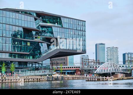 Paesi Bassi, Amsterdam - 8 aprile 2024: Edificio di recente costruzione per l'hotel e agente di vacanza Booking.com presso l'Oosterdok Foto Stock