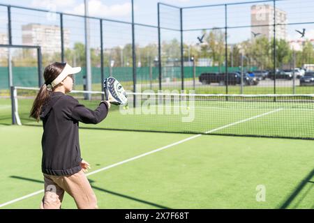 Ucraina Kiev, 20 aprile 2024. bella ragazza felice che pratica lo sport del paddle sul campo da paddle Foto Stock