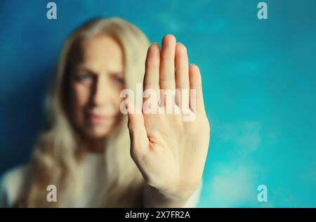 La giovane donna arrabbiata mostra stop, nessun segno o abbastanza con il palmo della mano, gesto di rifiuto, violenza domestica Foto Stock