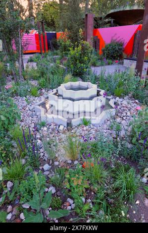 Londra, Regno Unito. 20 maggio 2024. Giorno di apertura al 2024 Royal Horticultural Society Chelsea Flower Show - uno dei giardini in mostra: Il RHS Chelsea Repurposed Garden. Riproponendo elementi di Show Gardens dal 2010, questo giardino celebra il riciclo creativo. Colonne in acciaio Corten della torre giardino del 2010 di Andy Sturgeon su pavimentazione bonificata, mentre la fontana e le panchine di ispirazione islamica di Tom Massey forniscono aree di riposo. Le pinne d'acciaio del giardino di Sturgeon del 2016 mostrano pratiche sostenibili. Le specie resistenti alla siccità sono piantate in calcestruzzo frantumato e sabbia da edifici demoliti. CRE Foto Stock