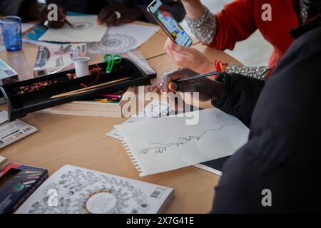 Briancon, Francia. 19 maggio 2024. Un esilio fa un disegno, Francia, Briancon, 19 maggio 2024. Un'infermiera di Medecins du Monde organizza un laboratorio di disegno e realizzazione di braccialetti con perline. Lo scopo di questo workshop è offrire momenti di relax ai migranti e stimolare la loro creatività per alleviare le loro ansie. Foto di Thibaut Durand/ABACAPRESS. COM credito: Abaca Press/Alamy Live News Foto Stock