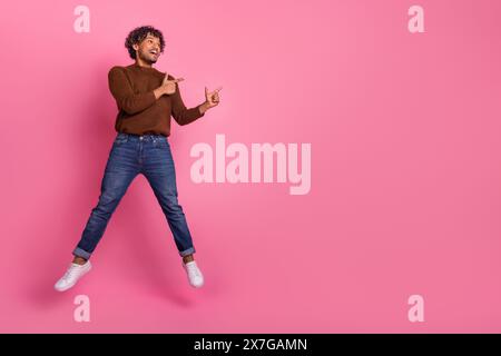 Foto di buon umore divertente uomo positivo indossare abiti marrone alla moda sembrano spazio vuoto isolato su sfondo di colore rosa Foto Stock