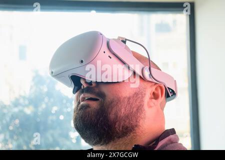 Uomo barbuto di mezza età con occhiali VR che esplora la realtà virtuale. Uomo in visore per realtà virtuale. Tecnologia moderna per il lavoro, l'istruzione e. Foto Stock