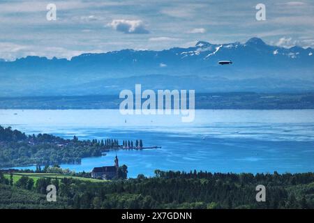 20 maggio 2024, Baden-Württemberg, Überlingen am Bodensee: lo zeppelin vola sul lago di Costanza verso Friedrichshafen, mentre la chiesa barocca di Birnau è visibile in primo piano. (Vista aerea con drone) foto: Felix Kästle/dpa Foto Stock