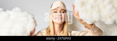 Una donna bionda in intimi pigiami tra soffici nuvole. Foto Stock