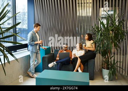 Un gruppo eterogeneo di colleghi in un moderno spazio di coworking, seduti su divani eleganti, impegnati in una vivace discussione. Foto Stock