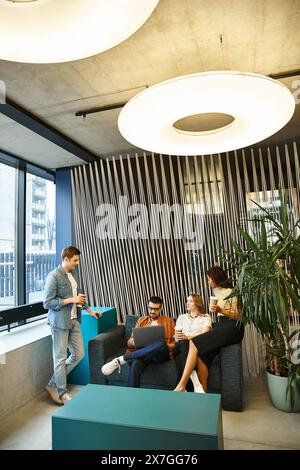 Un gruppo eterogeneo di colleghi in un moderno spazio di coworking, seduti e impegnati in una sessione di brainstorming. Foto Stock