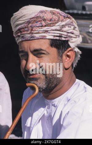 Mascate, Oman, Penisola Araba. Omani Man, un impiegato governativo, che indossa il tradizionale turbante Oman, un msarr o massar, e un disdasha bianco. Foto Stock