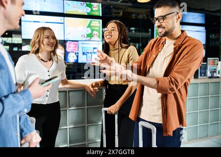 I colleghi multiculturali si riuniscono nella hall di un hotel e si impegnano in conversazione e networking durante un viaggio d'affari. Foto Stock