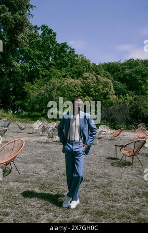 Bell'uomo afroamericano in tuta blu in un lussureggiante luogo verde. Foto Stock