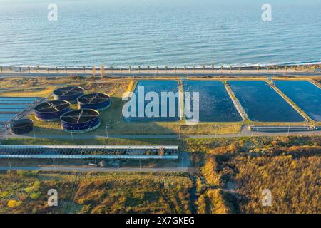 Vista aerea del moderno impianto di depurazione in riva al mare. Trattamento delle acque industriali con serbatoi d'acqua rotondi per il riciclaggio delle acque reflue dalla vista dei droni Foto Stock