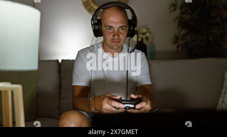 Giovane ispanico che gioca video gioco seduto sul divano a casa Foto Stock