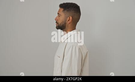 Profilo di un giovane afroamericano con la barba, con abbigliamento casual, in piedi su uno sfondo bianco isolato Foto Stock