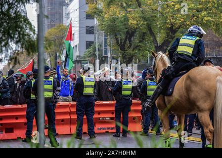 Manifestanti pro-palestinesi con bandiere sono visti davanti a ufficiali a cavallo e regolari che tengono una linea mentre sorvegliano i sostenitori pro-palestinesi separati dal Rally pro-ebraico. Sei persone sono state arrestate a seguito di accesi scambi tra manifestanti filo-palestinesi e filo-israeliani nel CBD di Melbourne. Una folla combinata di 7000 persone ha partecipato al Nakba Sunday Rally separato, e a Never Again Is Now Rally organizzato dal gruppo sionista cristiano Ambasciata cristiana internazionale di Gerusalemme. Ha capito alcuni manifestanti del Nakba Sunday Rally, iniziato a mezzogiorno intorno al Merg della Biblioteca di Stato Foto Stock