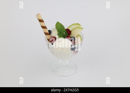 Gelato con mirtilli freschi, bastoncino di menta e cialda in vaso di vetro isolato su sfondo bianco. Foto Stock