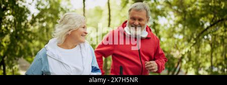 Sport stimolante. Persone anziane felici sorridenti, uomini e donne in abbigliamento sportivo jogging nel parco pubblico la mattina presto. Banner Foto Stock