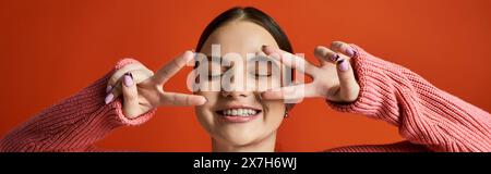 Una ragazzina bruna in un abbigliamento casual tiene le mani davanti agli occhi, creando un effetto simile a un velo. Foto Stock