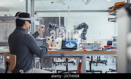 Studente di ingegneria maschile che indossa le cuffie AR, progetta e manipola la mano del robot utilizzando i controller. Design futuristico della realtà virtuale e concetto di applicazione professionale a tecnologia mista. Foto Stock